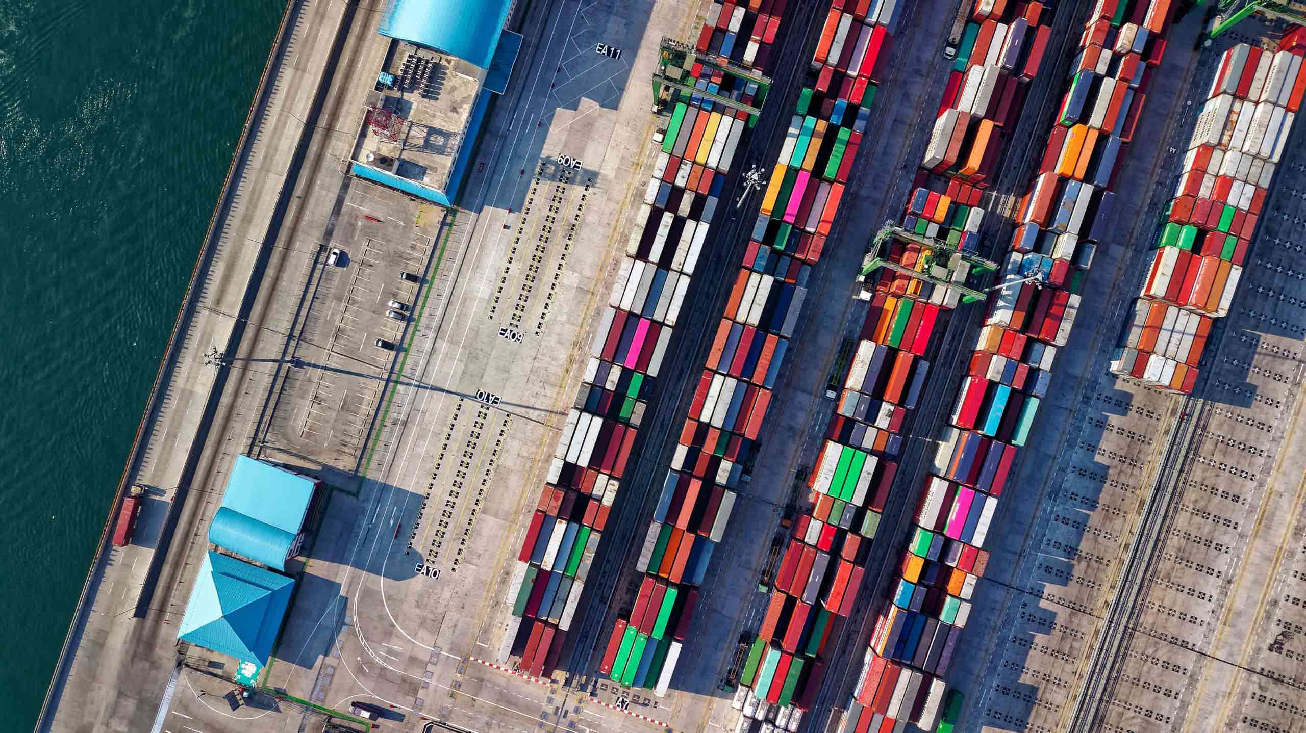 An aerial view of a container ship docked at a port, serving as a transportation services company case study.